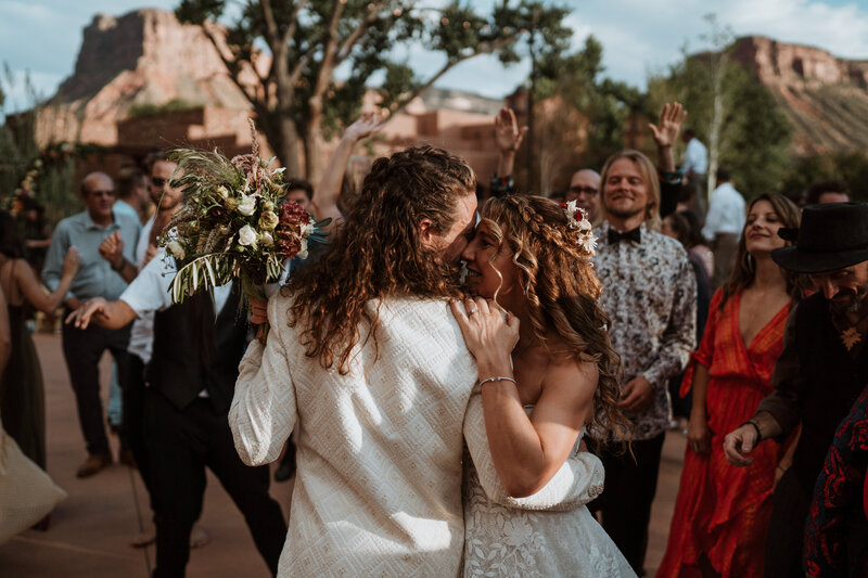 Newlyweds embrace joyfully on the dance floor, surrounded by guests and red rock views near Breckenridge, Colorado.