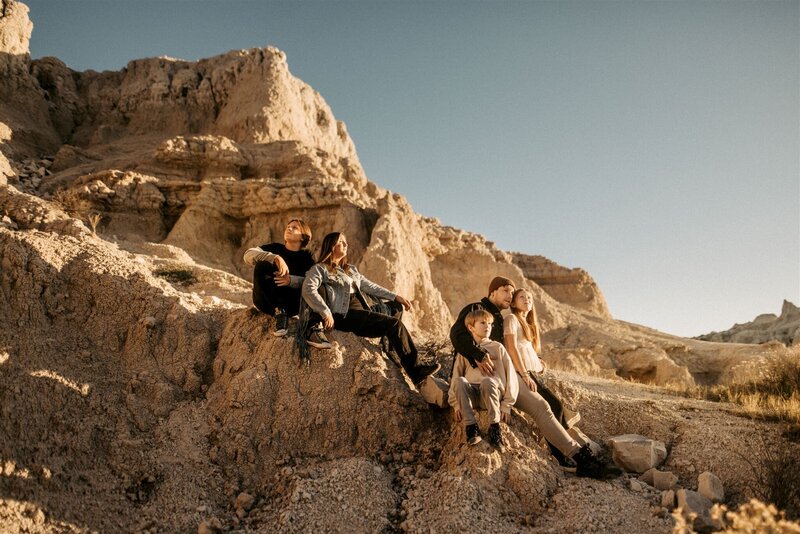 A portrait of a family sitting on the rocks in Badlands, South Dakota