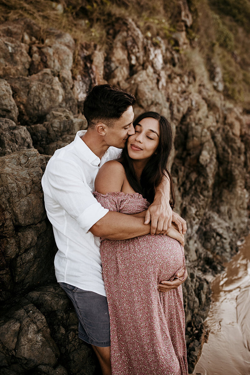 pregnant couple snuggling