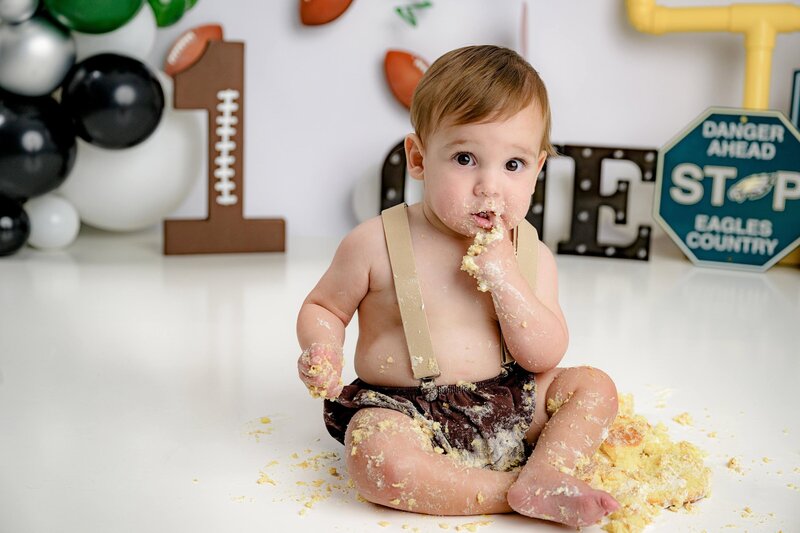 one year old boy from matthews sits in his customized eagles themed cake smash session for his one year old birthday portraits