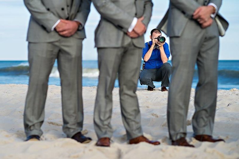 A creative image of Russ Hickman photographing a wedding on the beach in LBI, NJ.