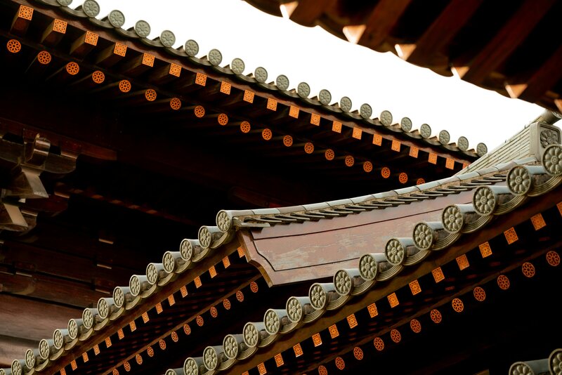 Intricate Chinese rooftops with orange, white and wooden details.
