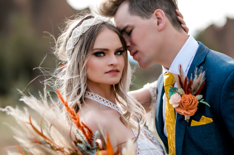 Close-up of a newlywed couple sharing an emotional moment, showcasing candid photography by an Oregon Coast Elopement and Wedding Photographer.