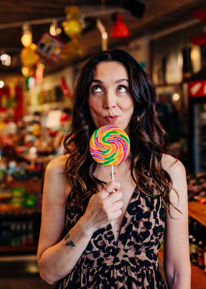 Branding Headshot of Maria Riboli holding up a large lollipop