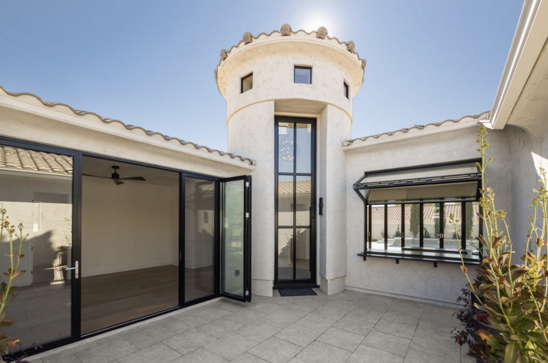 Exterior view of a Phoenix, Arizona home's patio windows and doors. Large multi sliding glass door system and picture windows.