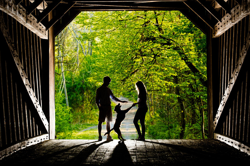Silhouette of a couple with their dog at Tyler State Park, capturing a heartfelt moment during their engagement session.