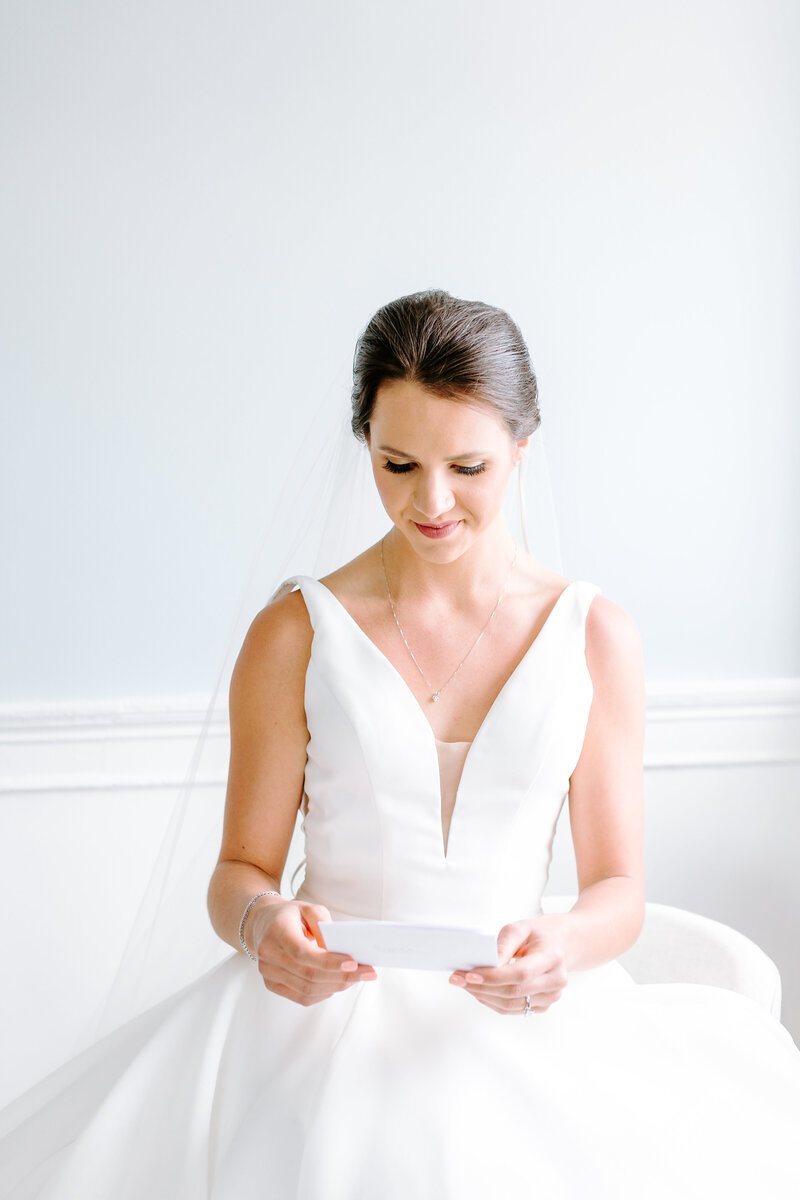 bride reading letter from groom in bridal suite