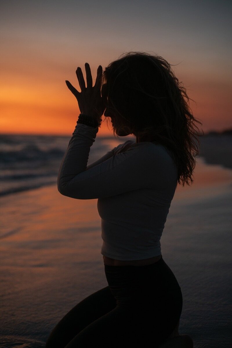 Stephanie in a yoga pose on the beach at sunset 