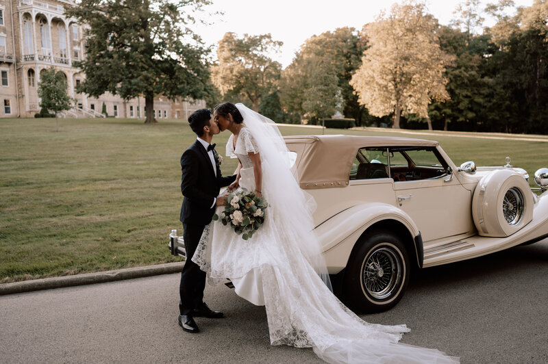 Catholic bride and groom kiss outside of monastery in Milwaukee, Wisconsin after their wedding mass