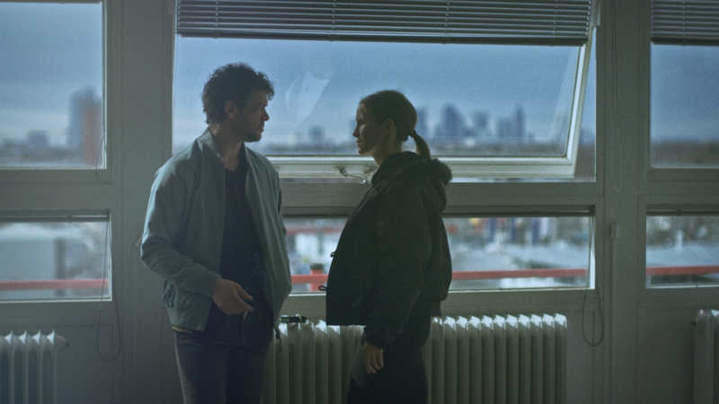 A nighttime urban street scene with moody lighting and cinematic tension.