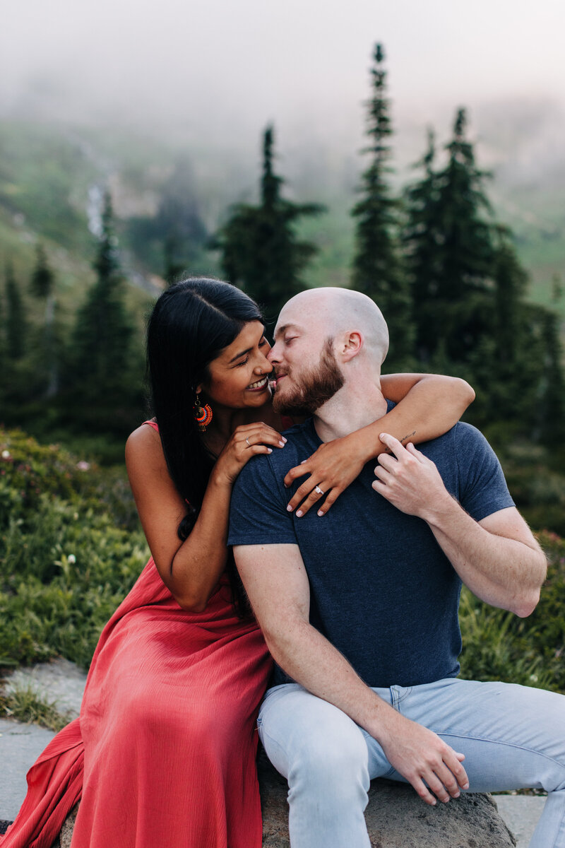 Mixed race couple share a light hearted kiss in Mt Rainier National park during their engagement session