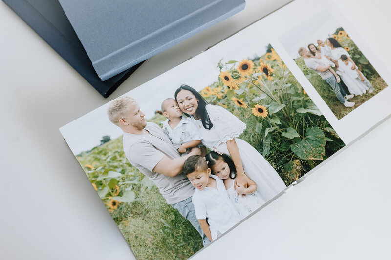 A family heirloom album lies open and shows printed images of family photos in the sunflower fields in Illinois. 