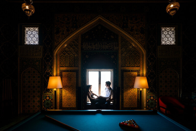 San Francisco wedding photographer captures couple portrait in Fairmont San Francisco's famous penthouse suite with Gothic arches and dramatic lighting