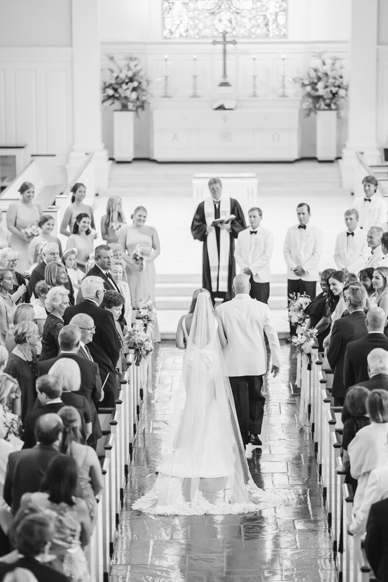 a bride and her father walking down the ceremony aisle at Canterbury UMC in Mountain Brook, Alabama