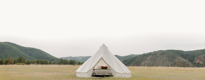 White Canvas Bell Tent with full sized bed and decorations