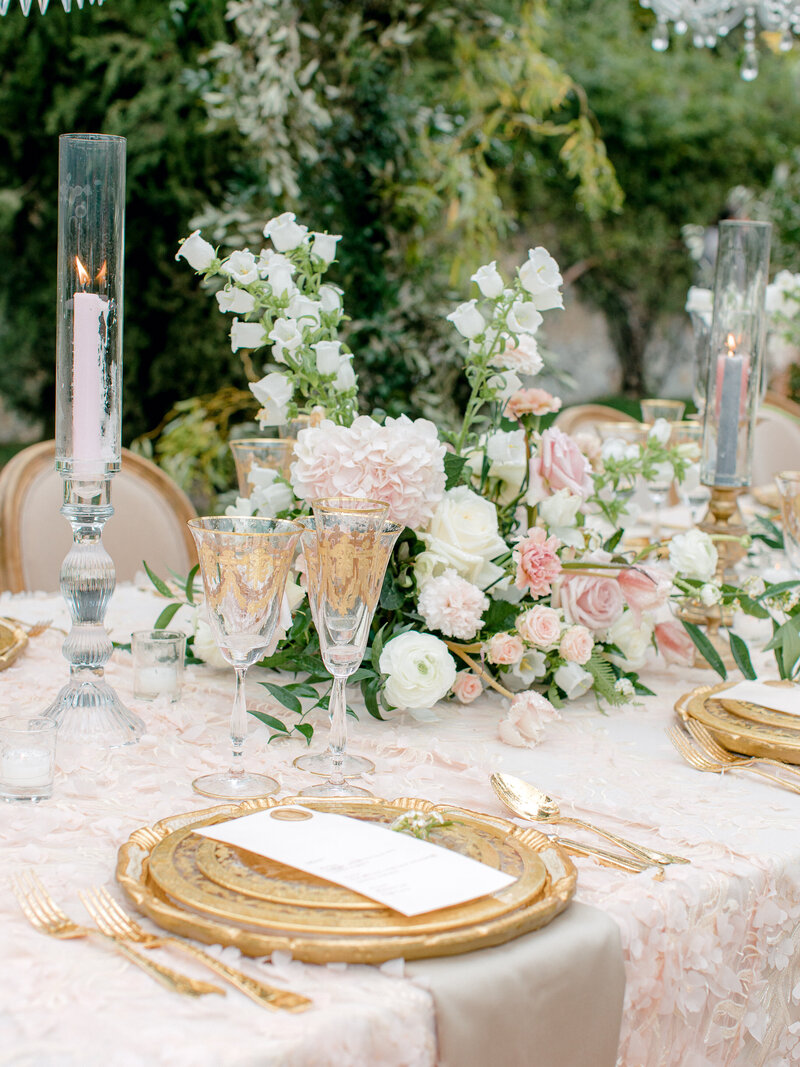 Close up of place setting on a pink, gold, and white reception table in Tuscany, Italy