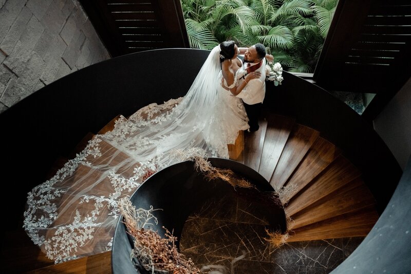 Nigerian wedding couple embraces on spiral staircase