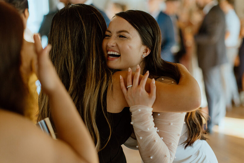 bride hugs friend and smiles