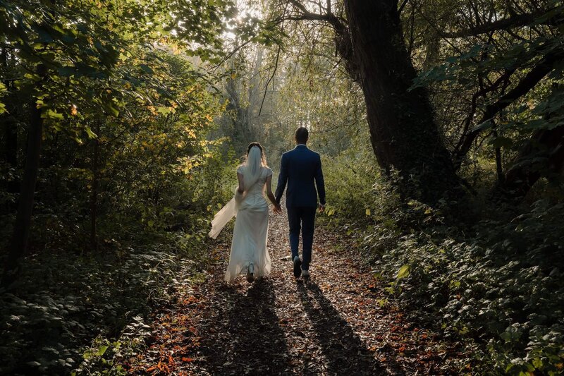 Bruid en bruidegom wandelen in het bos, gefotografeerd door Julia de Groot, trouwfotograaf uit Utrecht