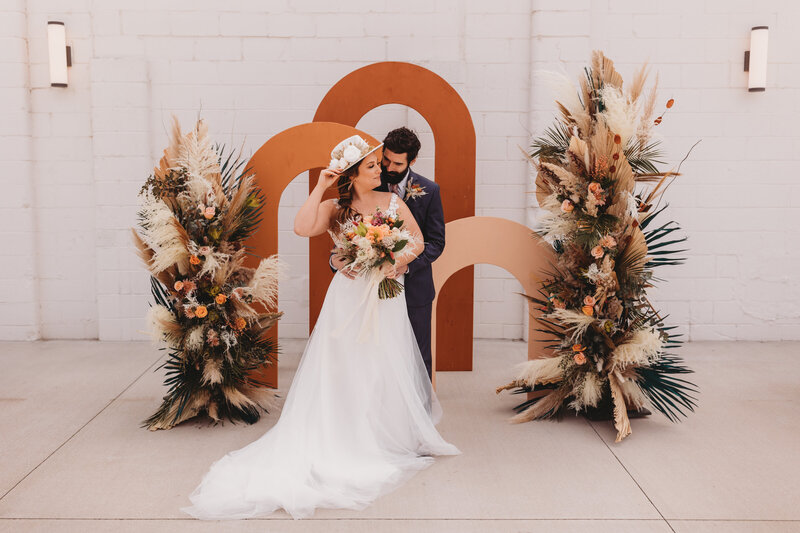 Wedding session photo of couple holding each other close with bouquet