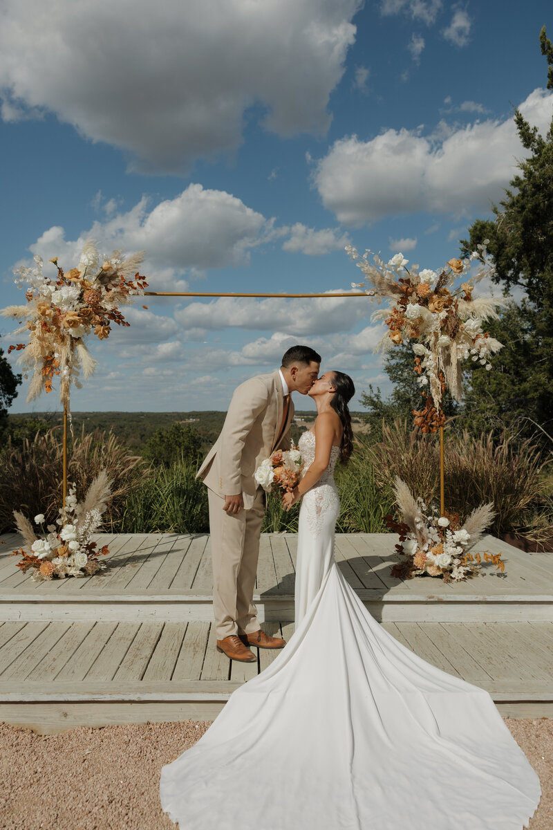 Bride and groom kissing at their ceremony site at Lucky Arrow Retreat.