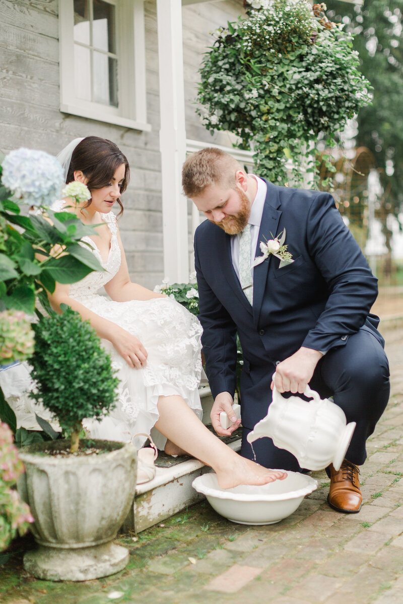 groom washing bride's feet at wedding