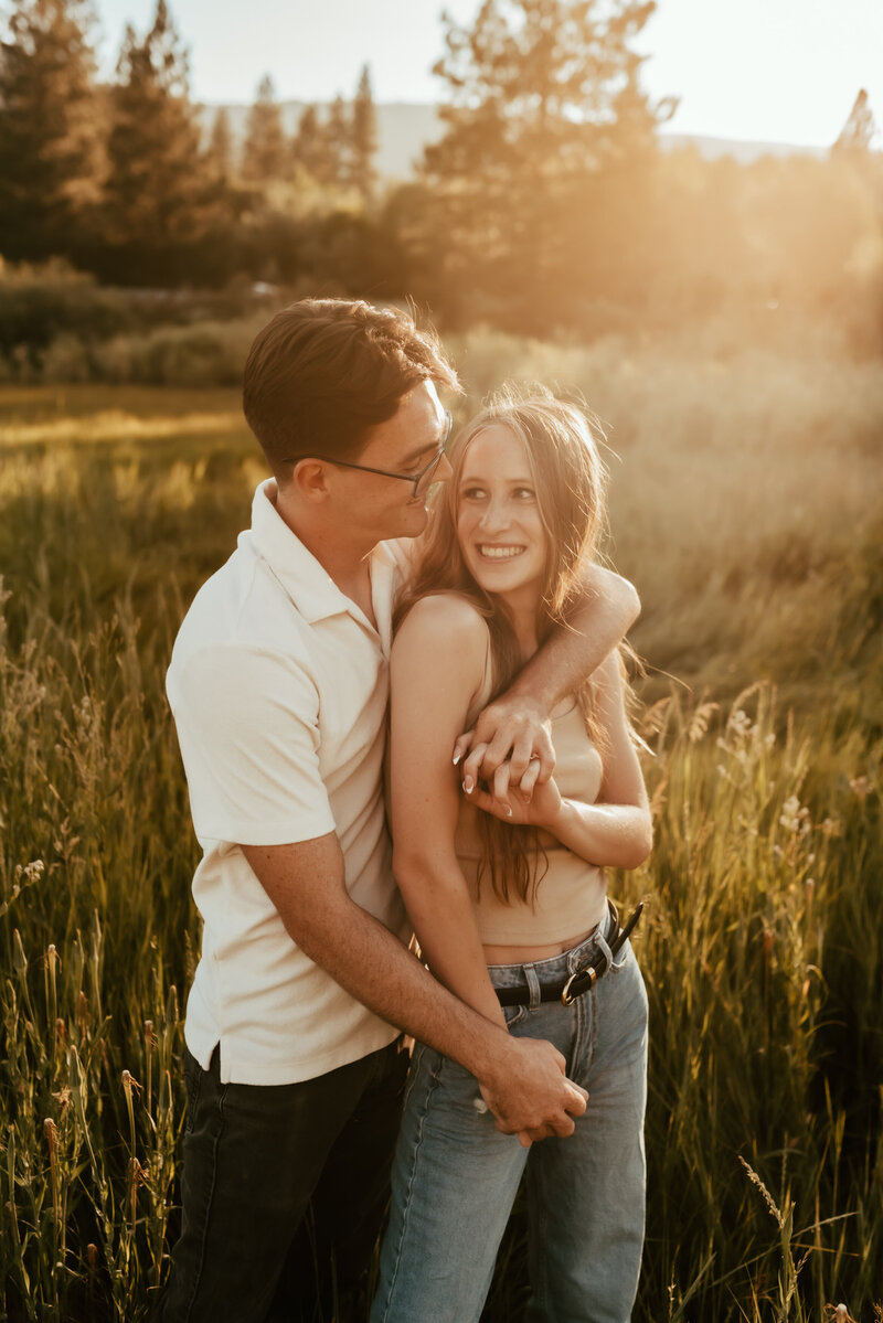 A couple wrapped around each other in a warm Tahoe sunset.