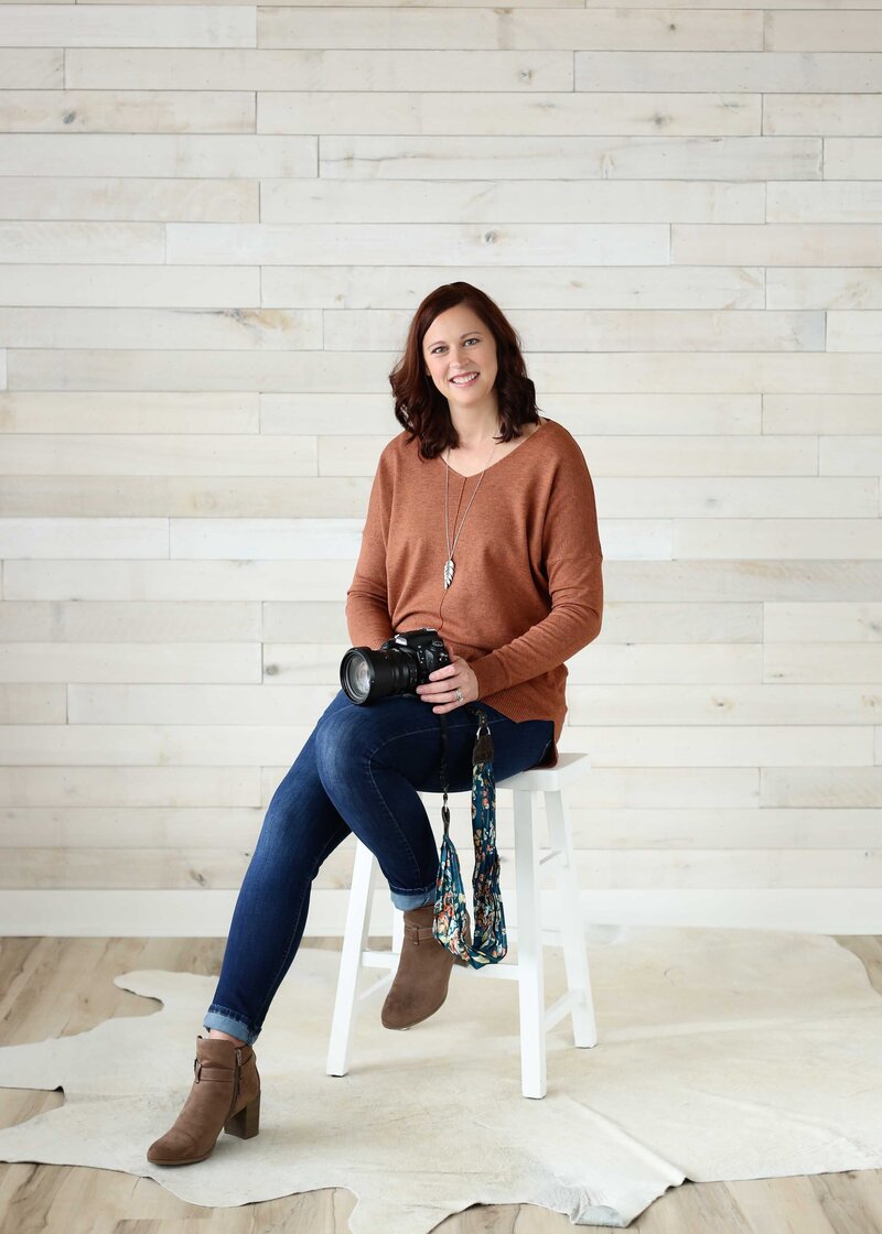 Woman Photographer Holding Camera Sitting on Stool