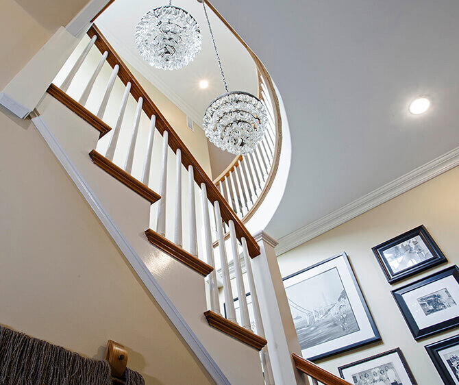 Staircase with framed photos and chandelier in Newton, MA
