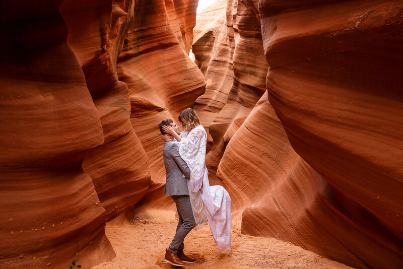 A dancing couple in a red rock slot canyon on their wedding day in Page, Arizona.