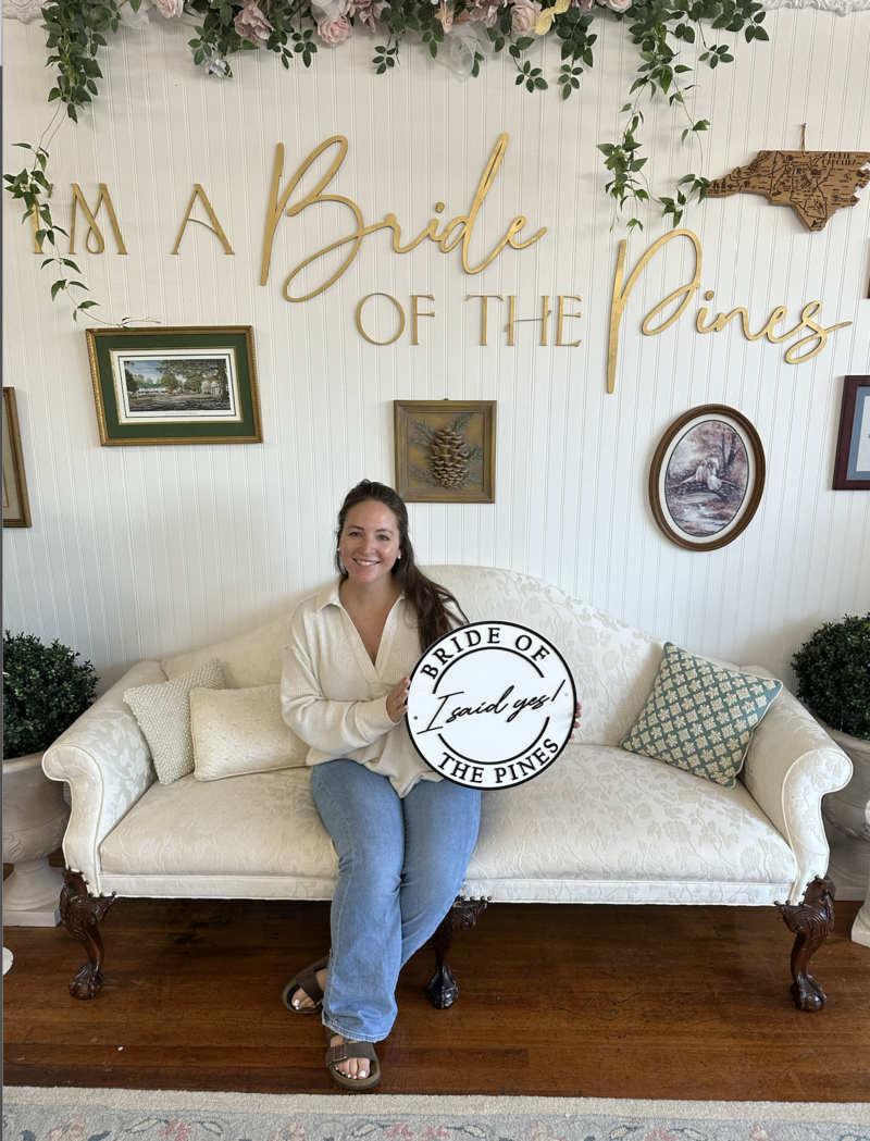 bride with I said yes sign in aberdeen nc wedding dress shop