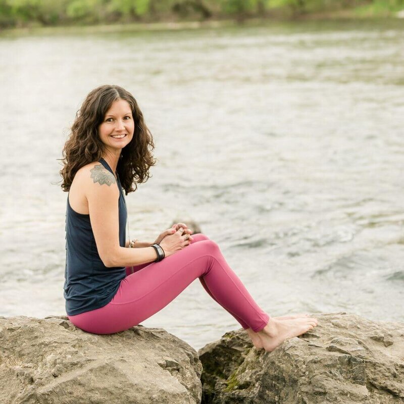 Rachel sitting on rock by river smiling
