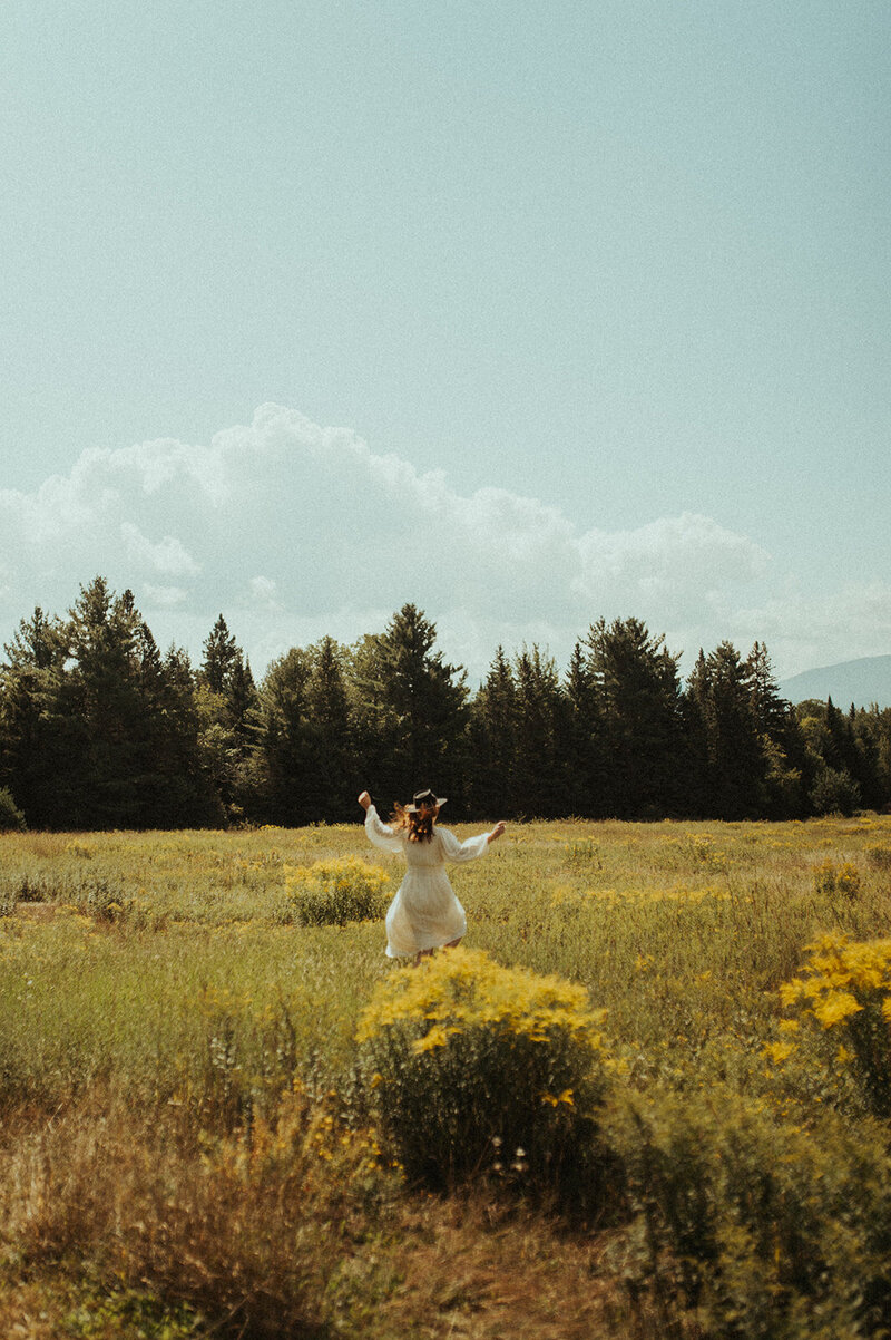 photographer dancing in field of wildflowers