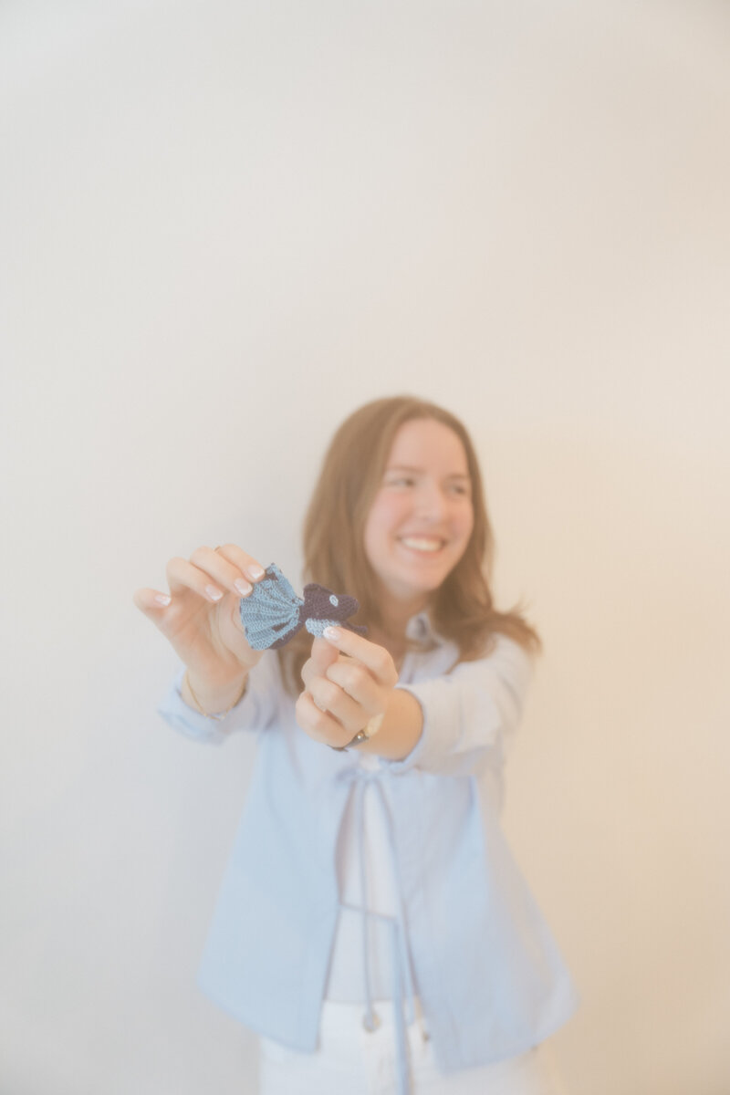 portrait of matilyn smiling beside a large leaf of a monstera deleciosa