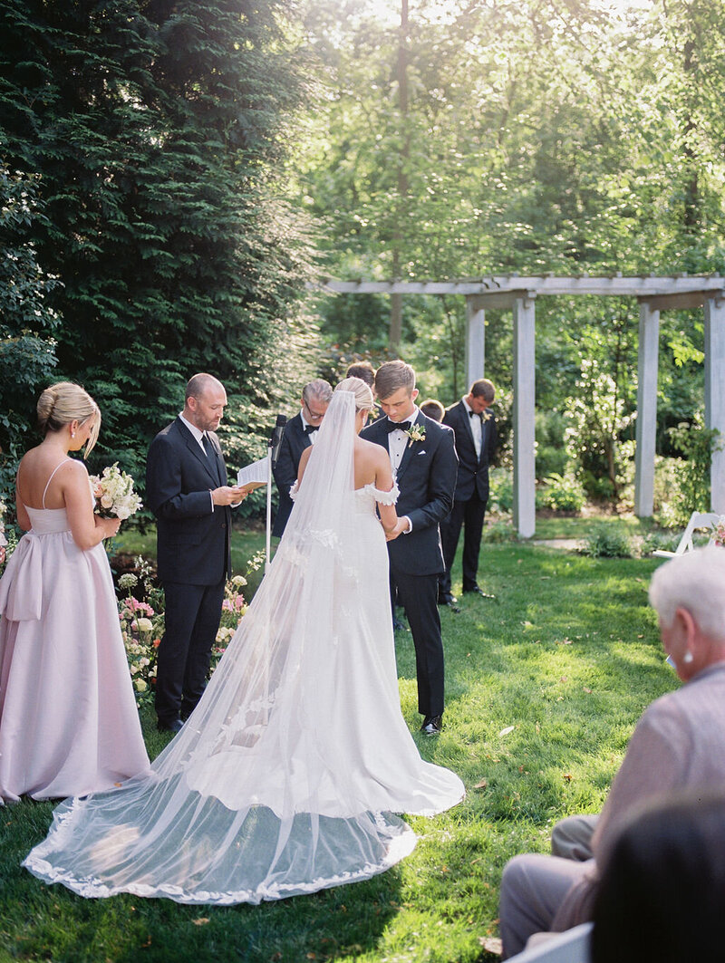 Bride and groom hold hands at wedding altar outside of the Anthony Wayne House in Pennsylvania