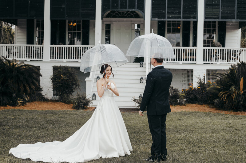bride and groom with umbrellas at agape oaks wedding