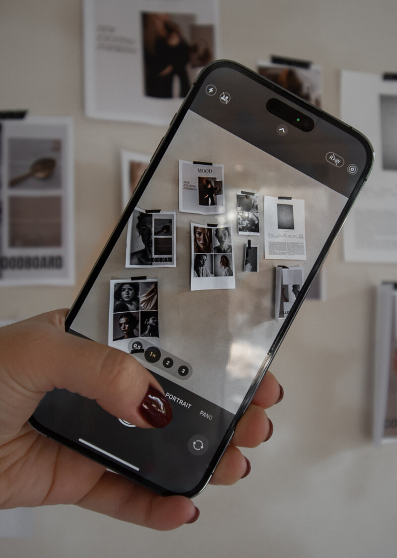 Phone taking photo of moodboard on the wall for a social media brand shoot