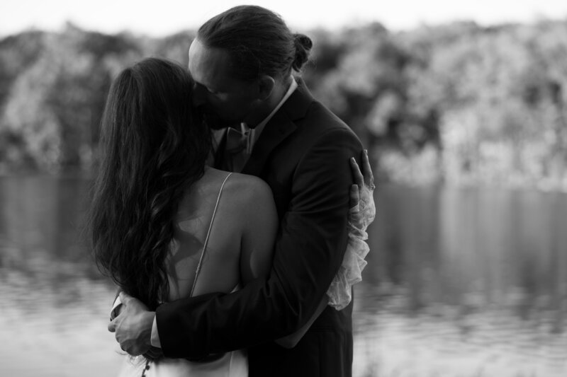 Eileen and Laz embracing on the lake before entering their reception in CT.