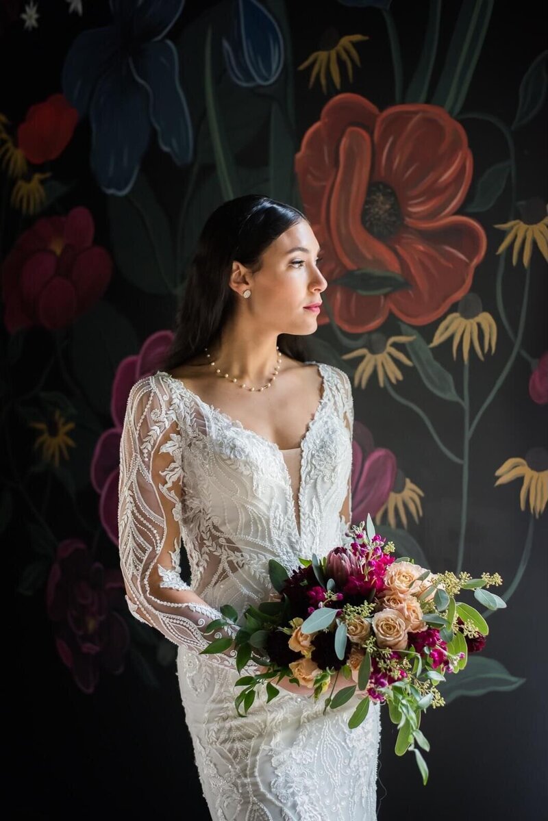 Bride holding bouquet looking out window