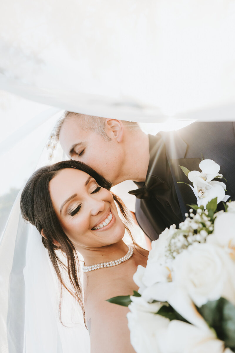 Bride and Groom kissing with cathedral in background