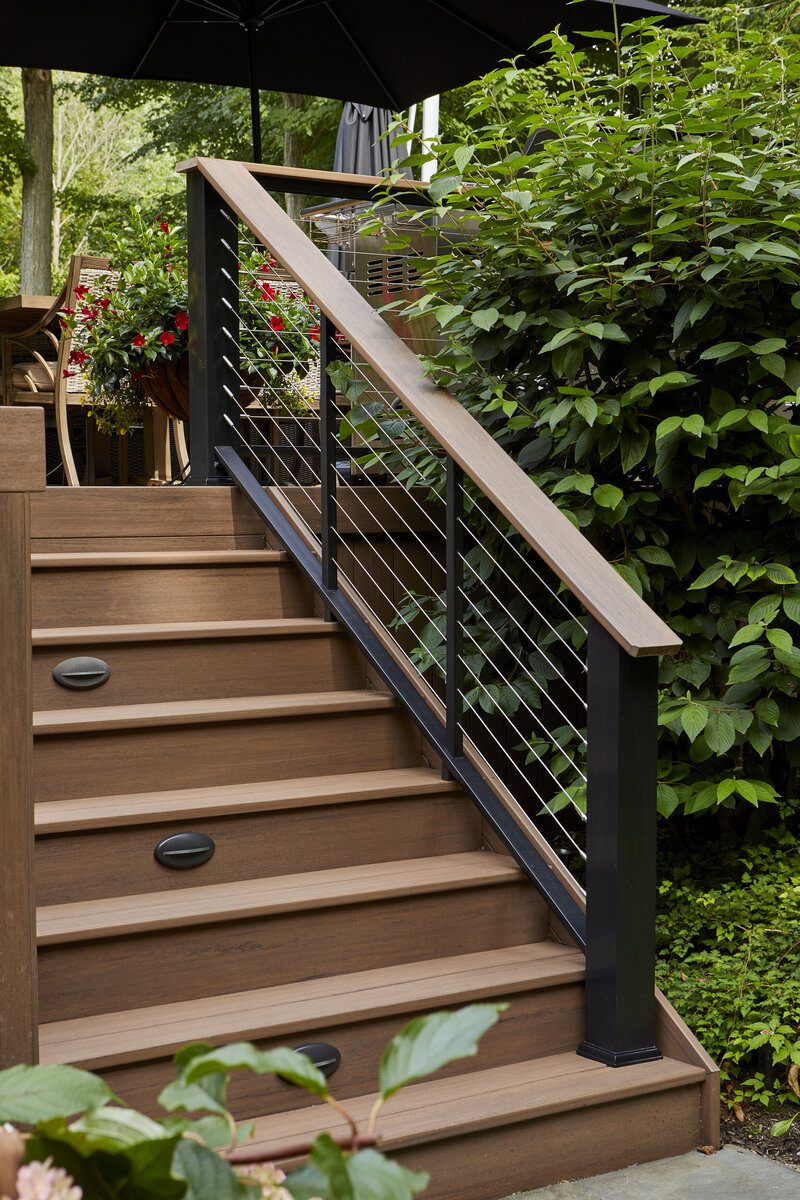 TimberTech Advanced PVC deck stairs with cable railing, drink rail, and riser lights. 