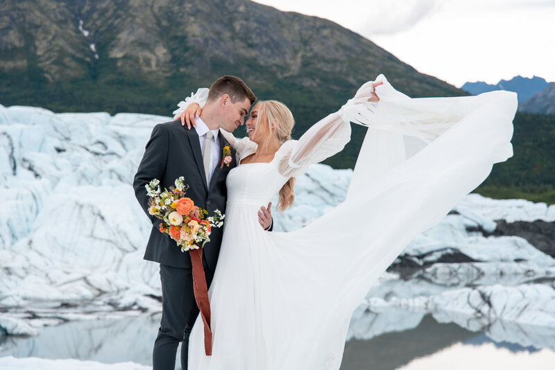 Alaska glacier bride and groom embrace in a mountain