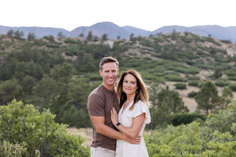 Chase and Brittany embrace in front of a mountain range in Colorado Springs. 