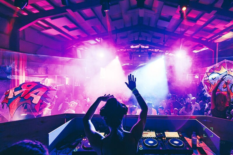 DJ performing rave in a warehouse