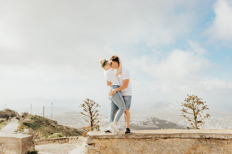 couple kissing on a ledge