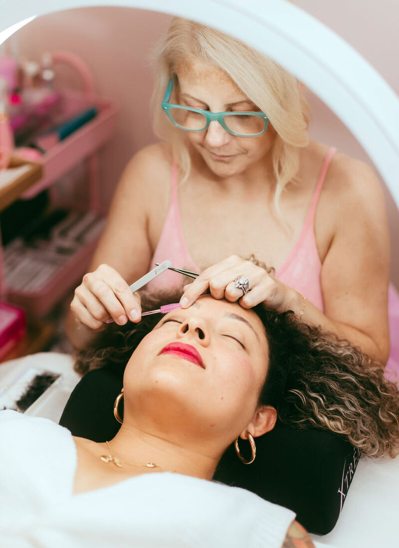 A woman receives  an eyelash extension