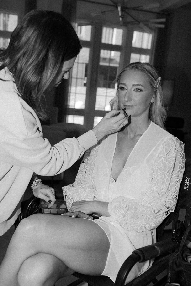 bride getting hair and makeup done in private home