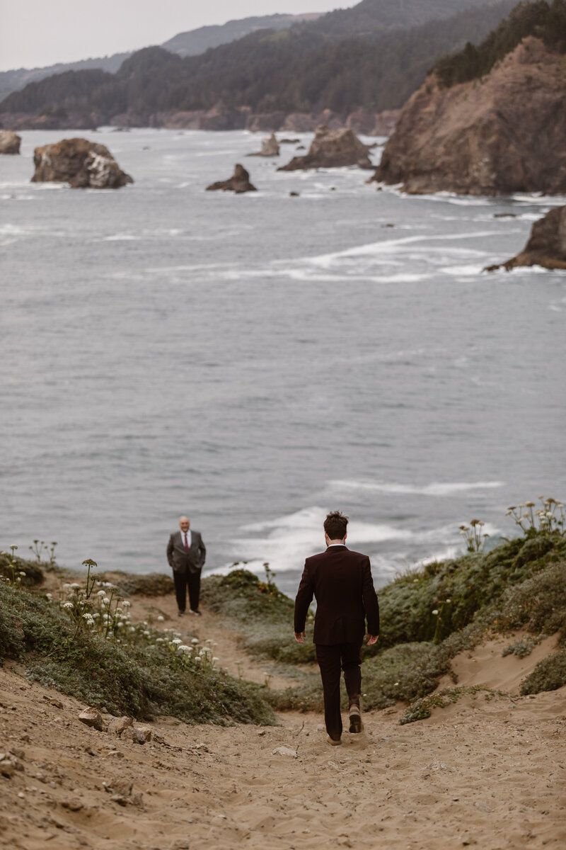 groom walking on cliffside