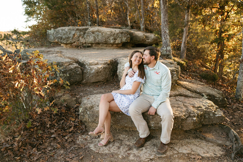 Warm photo of couple sitting on rocks at outdoor Nashville engagement session