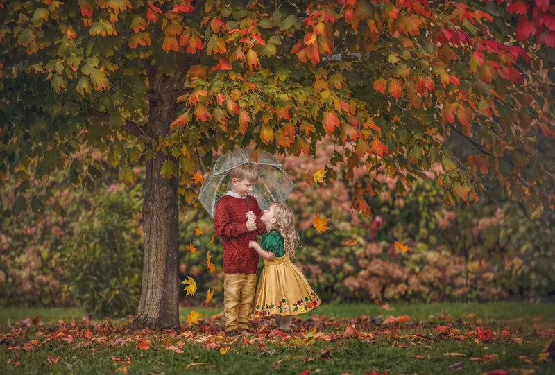 "Ottawa fall photo – siblings hugging under umbrella with falling leaves"